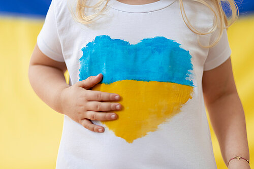 child wearing a t-shirt with Ukranian flag in a heart shape