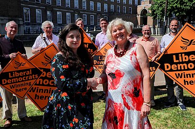 Cllr Zoe Peat and Cllr Jos Clark shaking hands in front of party activists